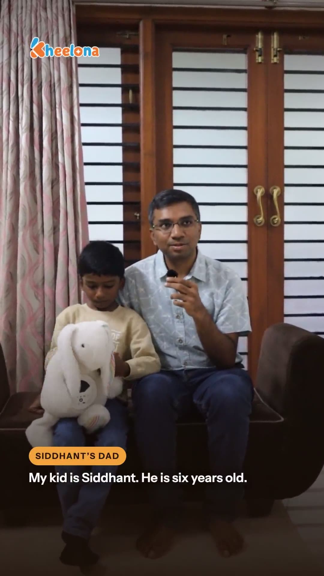 A father seated at home, speaking to camera.